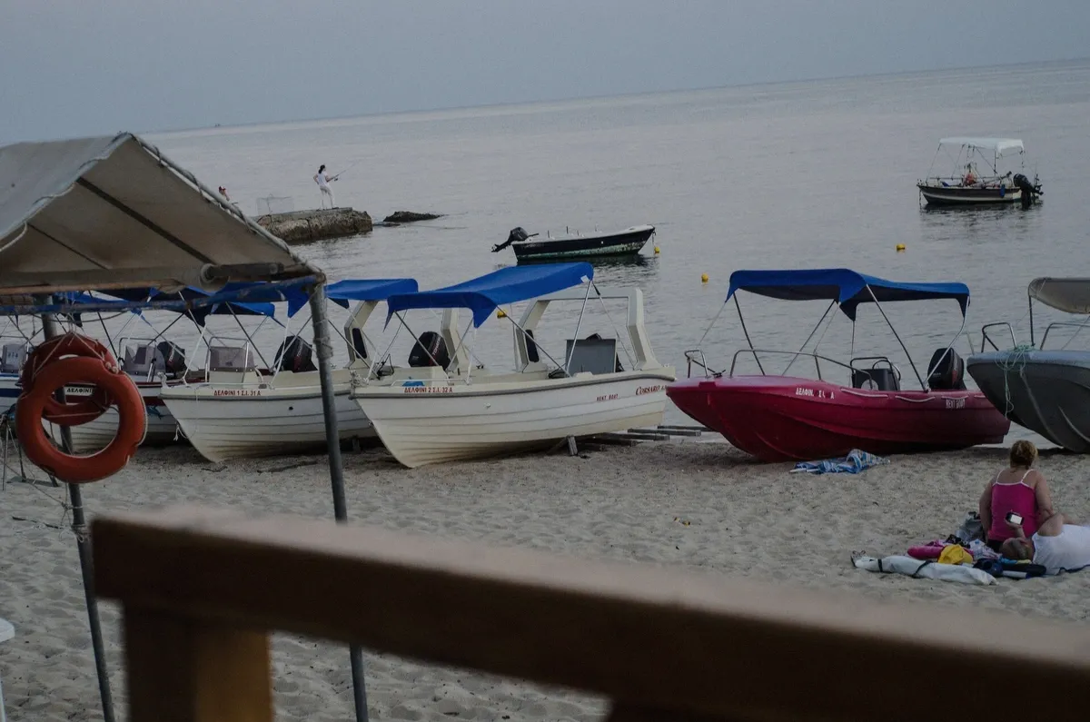 Traditional wooden Greek boats hauled on a beach in the Cyclades